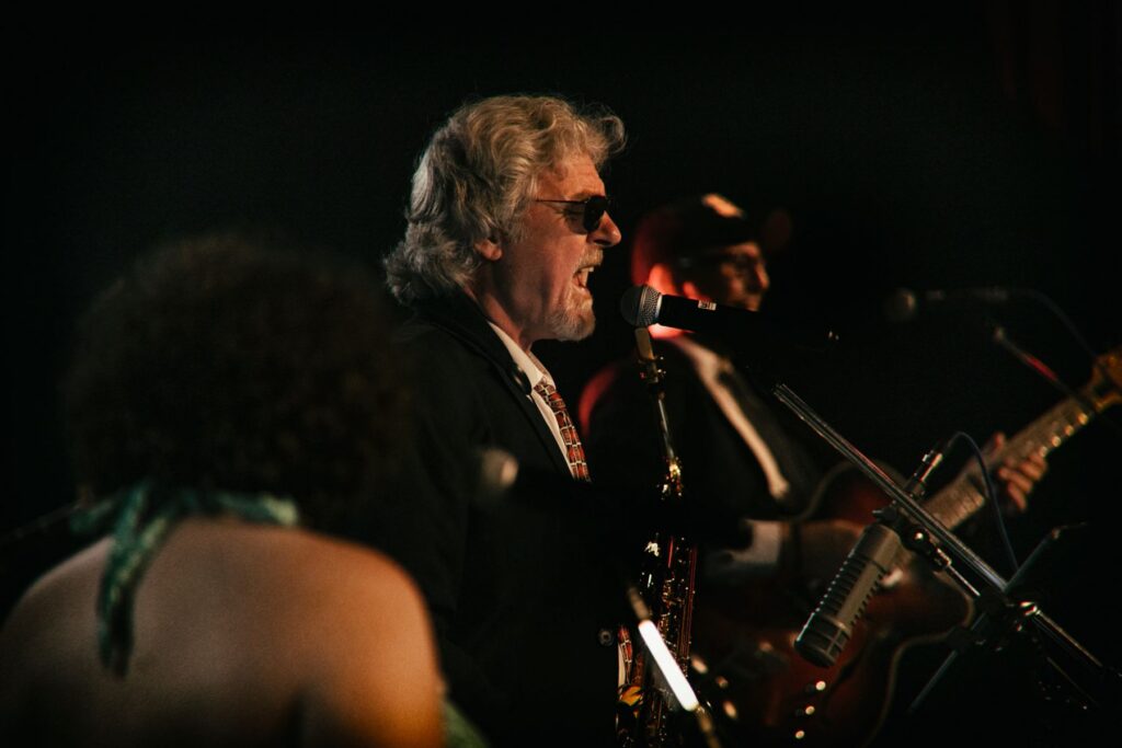 Dirk, Saxophonist der Beatroller, singend am Mikrofon beim Liveauftritt November 2023