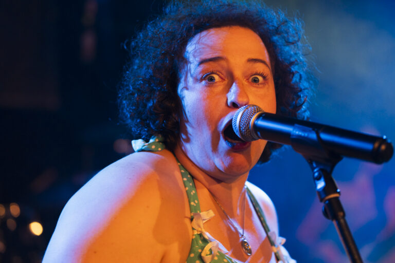 Tina, Sängerin der Beatroller, mit ausdrucksstarkem Gesichtsausdruck beim Liveauftritt November 2023
